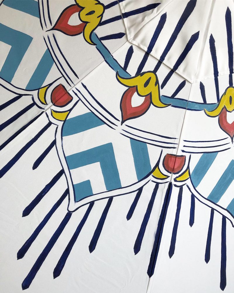 detail of an elegant blue and white patio umbrella by pearl and maude