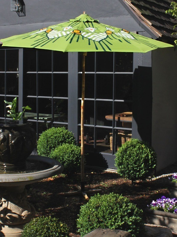 lotus custom patio umbrella in lime green in a beautiful garden - by pearl and maude