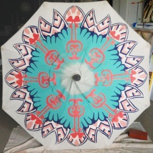 a hand painted patio umbrella in the process of being painted