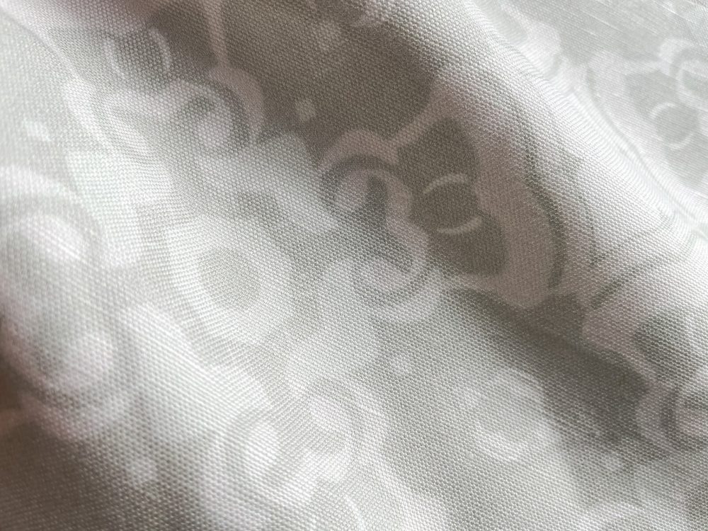 A fabric swatch of Pearl & Maude's medallion pattern Alexandria in sea neutral cream and white