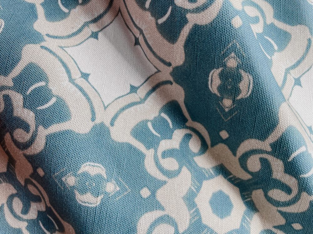 A fabric swatch of Pearl & Maude's medallion pattern Alexandria in sea blue, cream and white