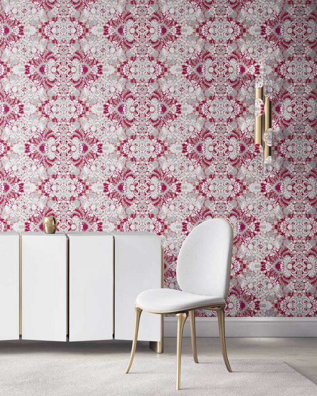 Pearl & Maude's abstract botanical Carmen nonwoven vellum wallpaper in berry pink and grey installed in a beautiful living room with white and brass furniture.