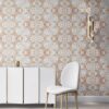 Pearl & Maude's abstract botanical Carmen nonwoven vellum wallpaper in clay pink, white and grey installed in a beautiful living room with white and brass furniture.