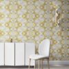 Pearl & Maude's abstract botanical Carmen nonwoven vellum wallpaper in daisy yellow, white and grey installed in a beautiful living room with white and brass furniture.