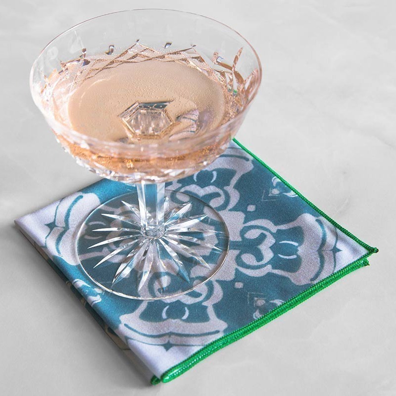 Alexandria Cloth Cocktail Napkin in sea blue with a crystal wine glass.