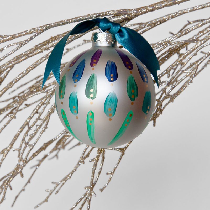 Steppin Out Christmas Tree Ornament is a hand painted glass ornament in shades of aubergine to teal and green