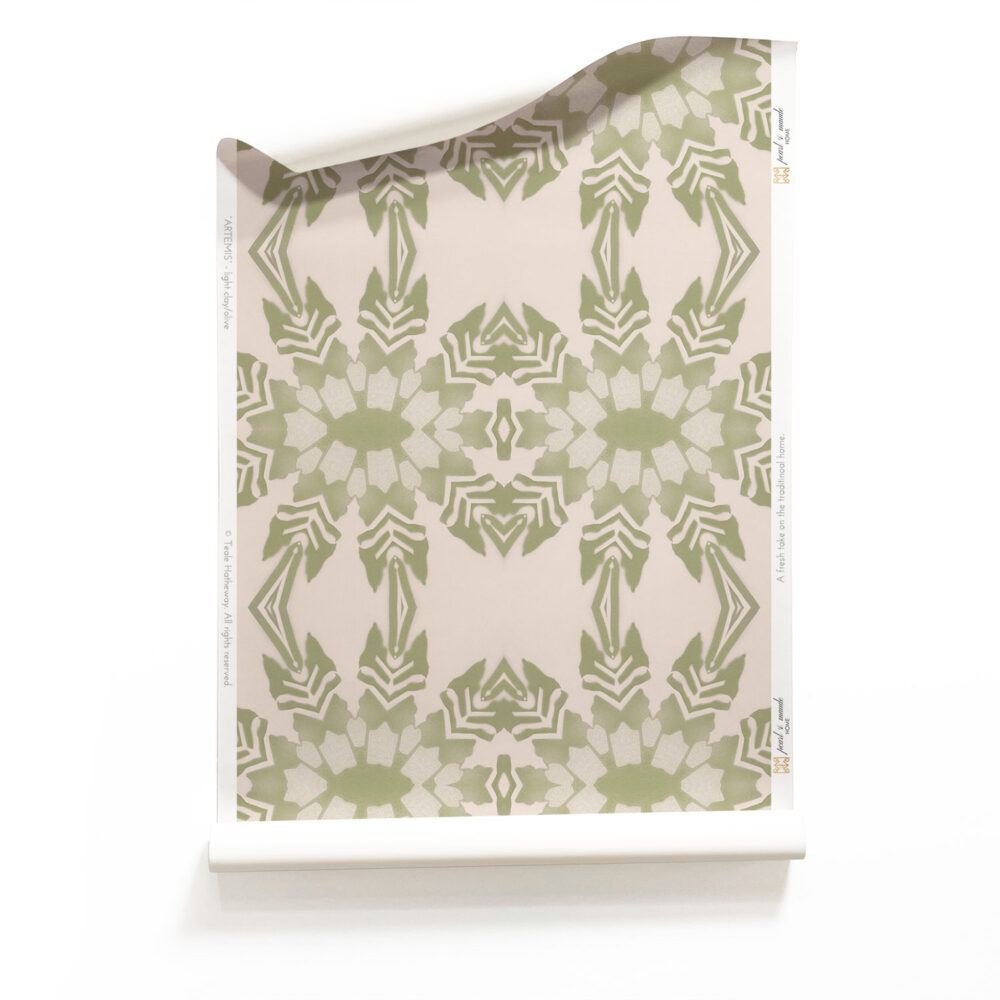 A roll of Artemis, Pearl & Maude's light pink tropical wallpaper with light green foliage, a pastel artisan wallpaper