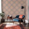A view of our Beaufort Sunburst Pattern Wallpaper in the Boardwalk colorway of brown and magenta. Installed on the wall of a sun filled, boho style sitting room, decorated with fine wood furniture, blue velvet seating and a Persian rug.
