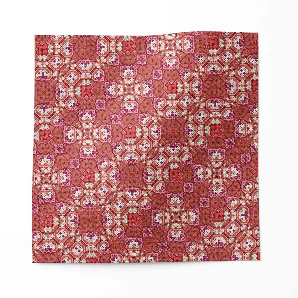 A swatch of Marshan red ornate patterned fabric that blends Americana style with Eastern pattern motifs