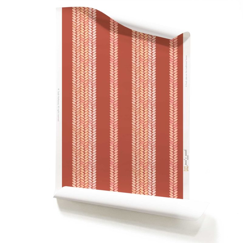 A roll of Perigrene wallpaper in colorway Saltillo. It is a woven stripe wallcovering in pink, peach and red colors. It's an ideal wallpaper for dining rooms.