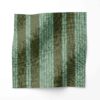 A swatch of Perigrene drapery fabric in colorway Ridge. It is a woven stripe fabric in olive, green and turquoise colors. It's an ideal fabric for draperies.