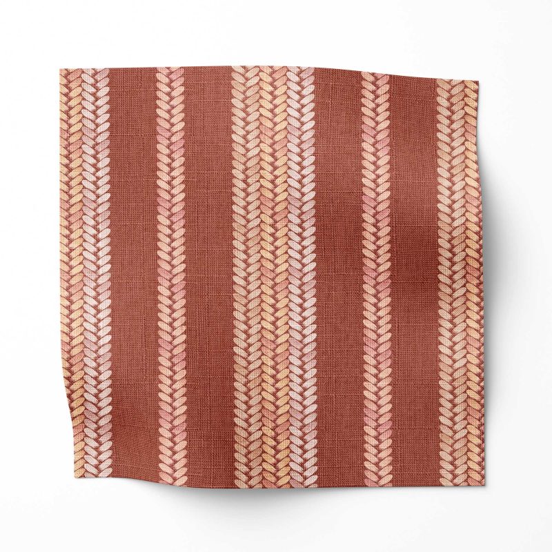 A swatch of Perigrene drapery fabric in colorway Saltillo. It is a woven stripe fabric in pink, peach and red colors. It's an ideal fabric for draperies.