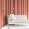 Perigrene wallpaper in colorway Saltillo, installed in a living room. It's warm red colors are inviting while it's brighter peach stripes add movement and depth.