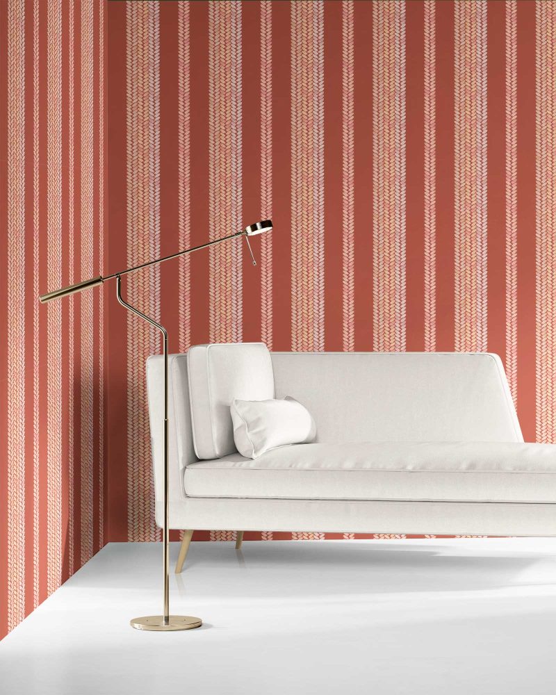 Perigrene wallpaper in colorway Saltillo, installed in a living room. It's warm red colors are inviting while it's brighter peach stripes add movement and depth.