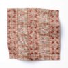 A swatch of "Ruguru" - an enchanting linen fabric pattern that showcases intricate linework, crafting a mesmerizing red tribal patterned fabric in a medium sized graphic pattern.