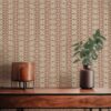 A closeup view of our Ruguru geometric tile wallpaper in the rust red and beige colorway. Installed on the wall of a room decorated with fine wood furniture