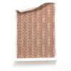 A roll of Ruguru Red Art Deco Wallpaper Small Scale in rust red and brown