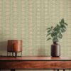 A closeup view of our Ruguru geometric tile wallpaper in the sage green and beige colorway. Installed on the wall of a room decorated with fine wood furniture