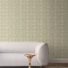our Ruguru geometric tile wallpaper, with an intricate repeat, in the sage green, white and beige colorway. Installed on the wall of a room decorated with fine white linen sofa and high end furniture