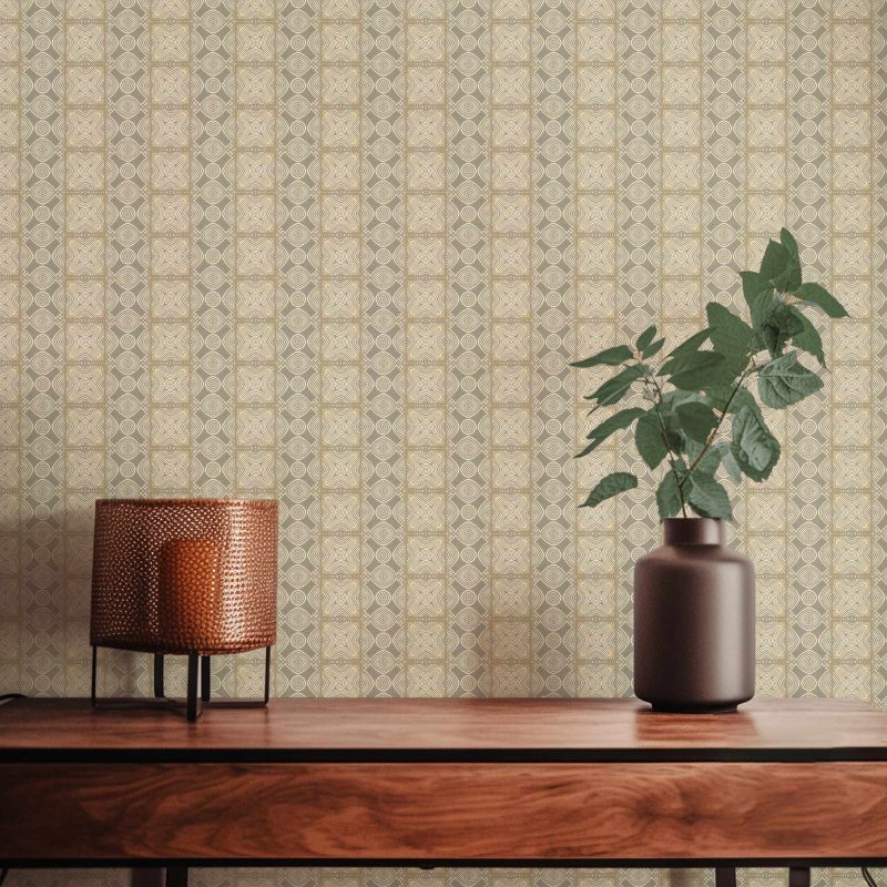 A closeup view of our Ruguru geometric tile wallpaper in the silt brown and beige colorway. Installed on the wall of a room decorated with fine wood furniture