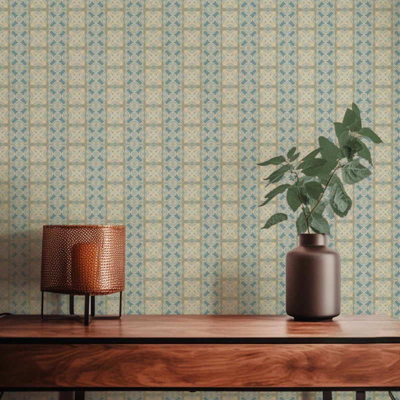 A closeup view of our Ruguru geometric tile wallpaper in the Spring Blue and beige colorway. Installed on the wall of a room decorated with fine wood furniture