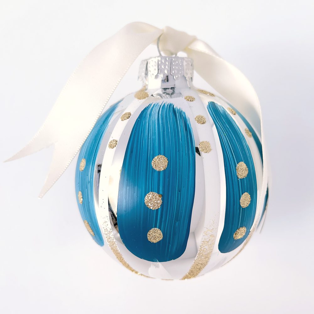 Hand painted Christmas ornament in blue and white with gold glitter and ivory satin ribbon.