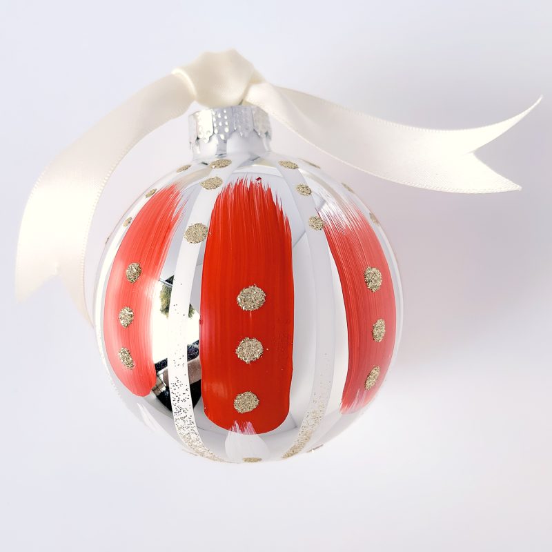 Hand painted Christmas ornament in red and white with gold glitter and ivory satin ribbon.