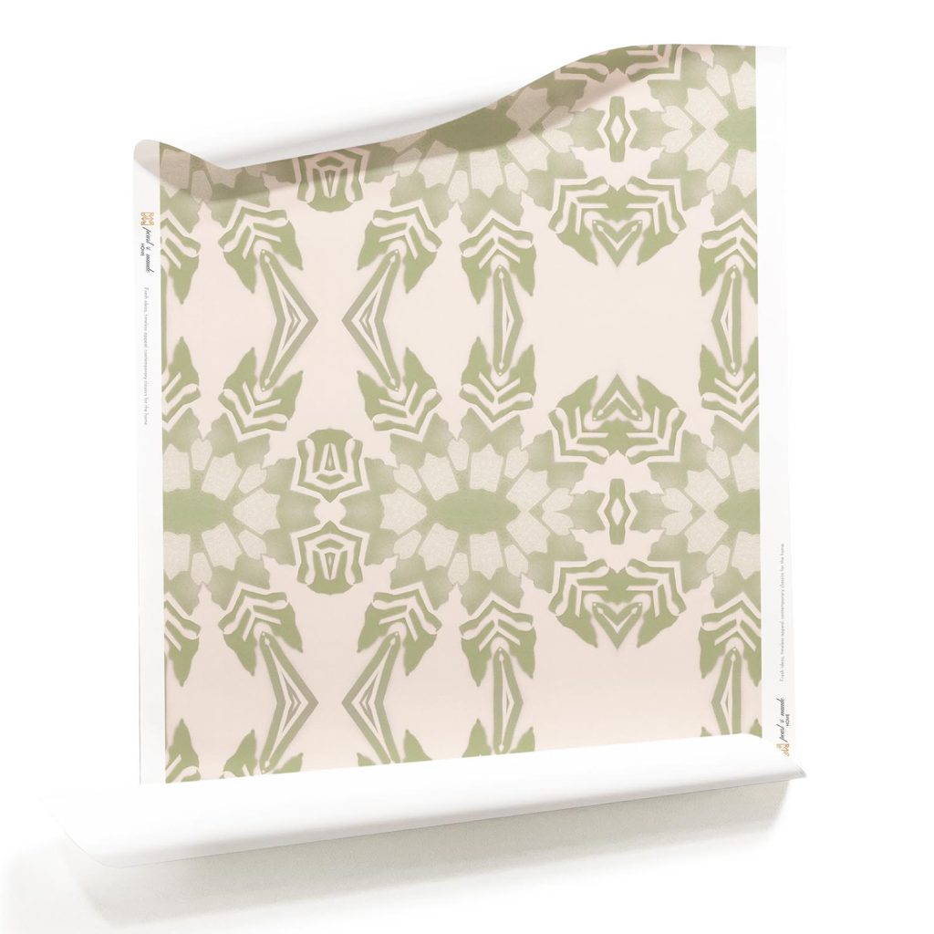 A roll of Artemis, Pearl & Maude's light pink tropical wallpaper with light green foliage, a pastel artisan wallpaper. Roll of light pink tropical wallpaper with symmetrical green foliage, perfect for creating serene and sophisticated interiors.