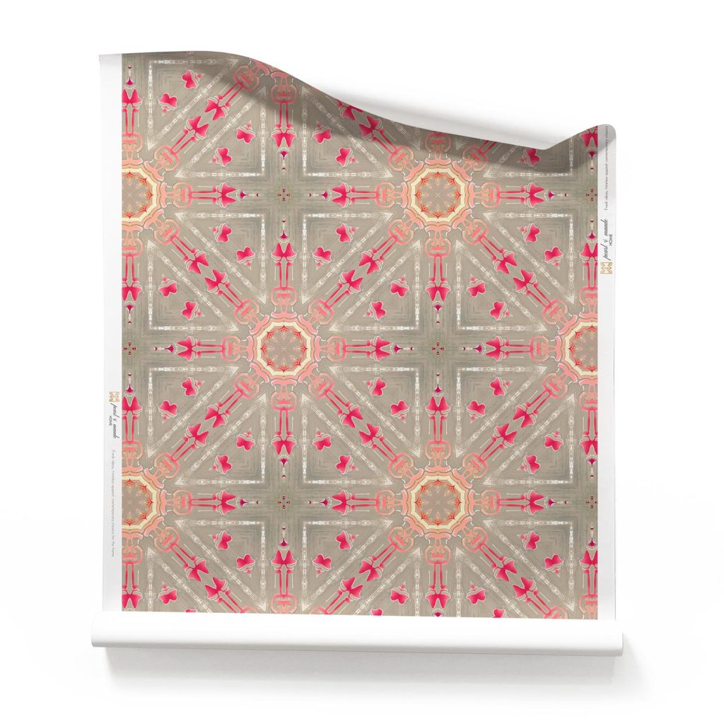 A roll of "Beaufort,” our brown starburst wallpaper - Beaufort brown starburst wallpaper featuring sandy brown and magenta medallions in a diamond grid pattern, perfect for boho and vintage-inspired interiors.