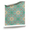 A roll of "Beaufort,” turquoise starburst wallpaper is a multicolor pattern. In the turquoise, pink and coral colorway, it draws inspiration from the laid-back, bohemian beach bungalows of 1960s Southern California.