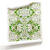 A roll of Carmen green and white botanical floral wallpaper with soft green and cool grey tones, featuring delicate floral patterns inspired by a secret garden.
