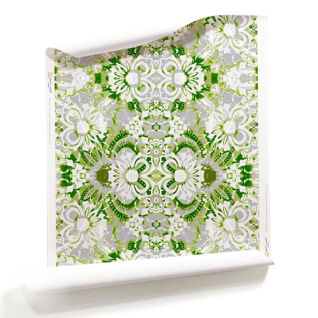 A roll of Carmen green and white botanical floral wallpaper with soft green and cool grey tones, featuring delicate floral patterns inspired by a secret garden.