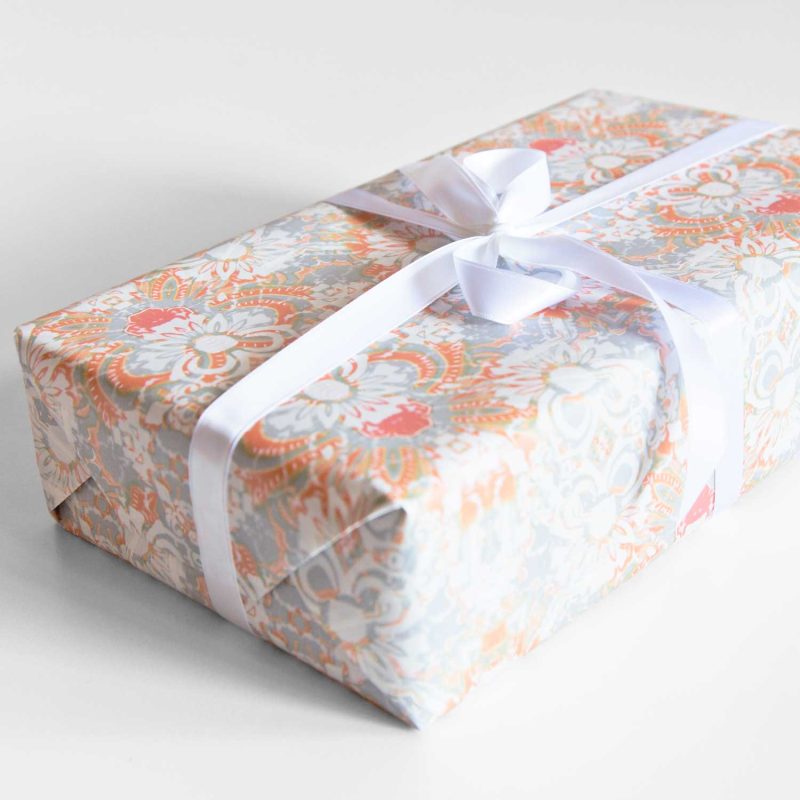 A gift wrapped in Carmen Apricot floral wrapping paper