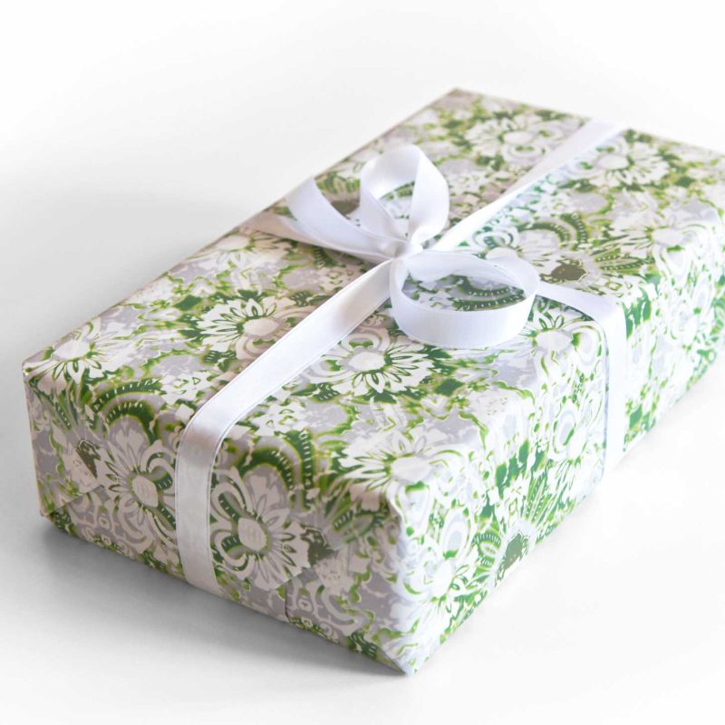 A box wrapped in Carmen wrapping paper in green and white foliage pattern