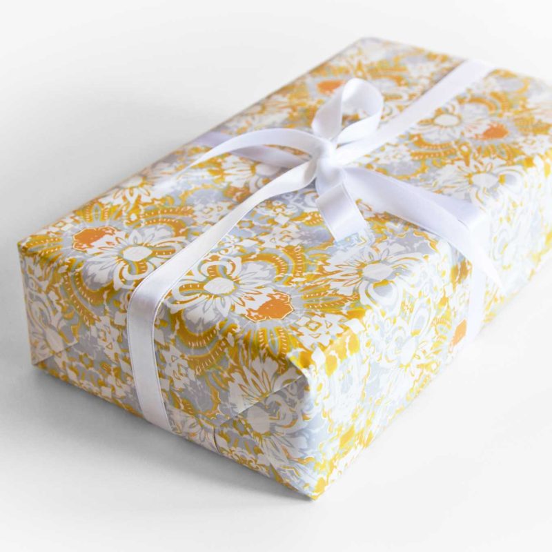 a gift wrapped with Carmen yellow floral gift wrapping paper