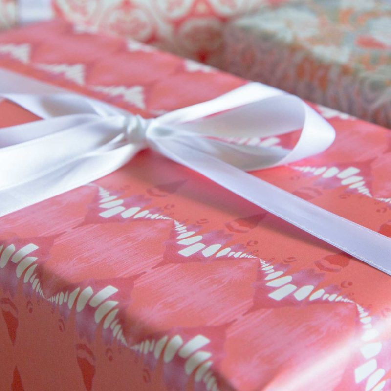 a gift wrapped with Evelyn melon red striped wrapping paper