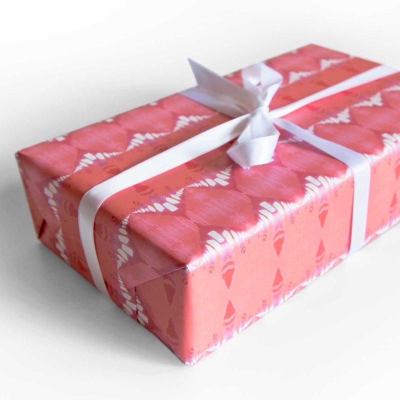 A gift wrapped with Evelyn melon red striped wrapping paper